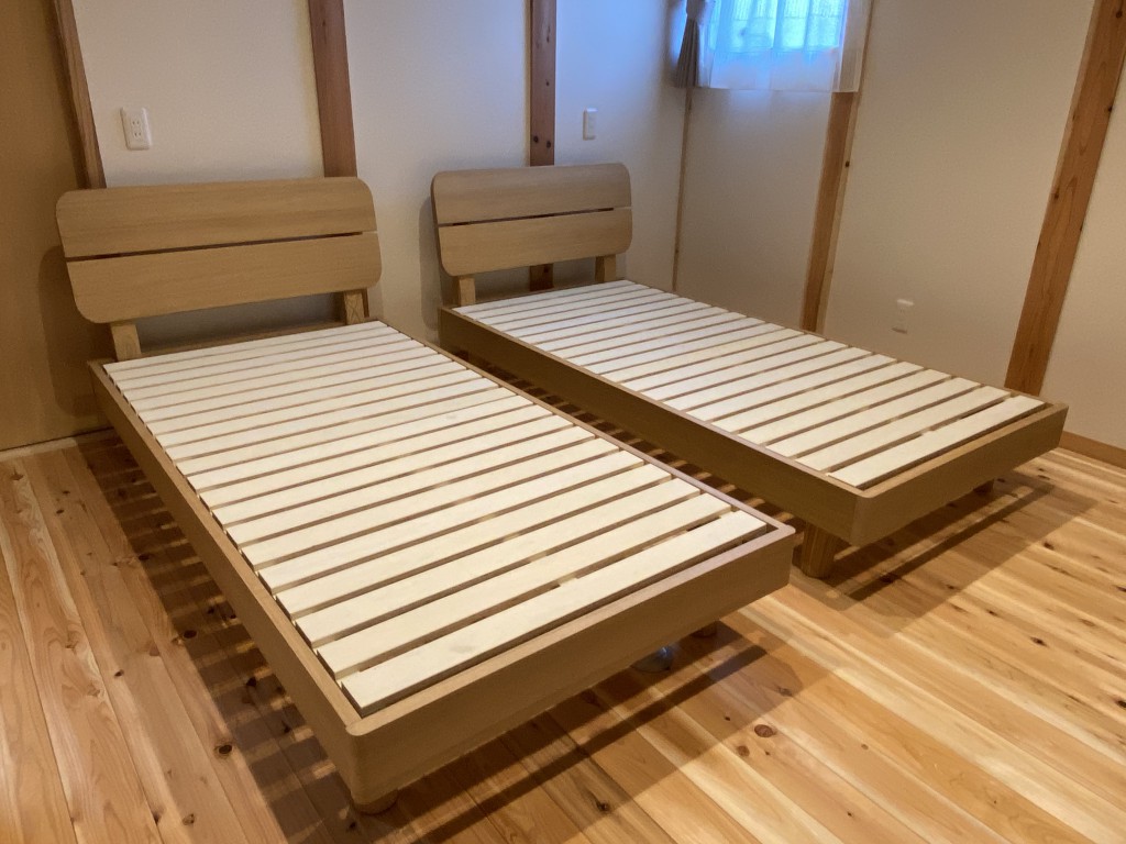 床が無垢材でナチュラルな雰囲気の中に、タモ材のベッドフレームがよく合っています。